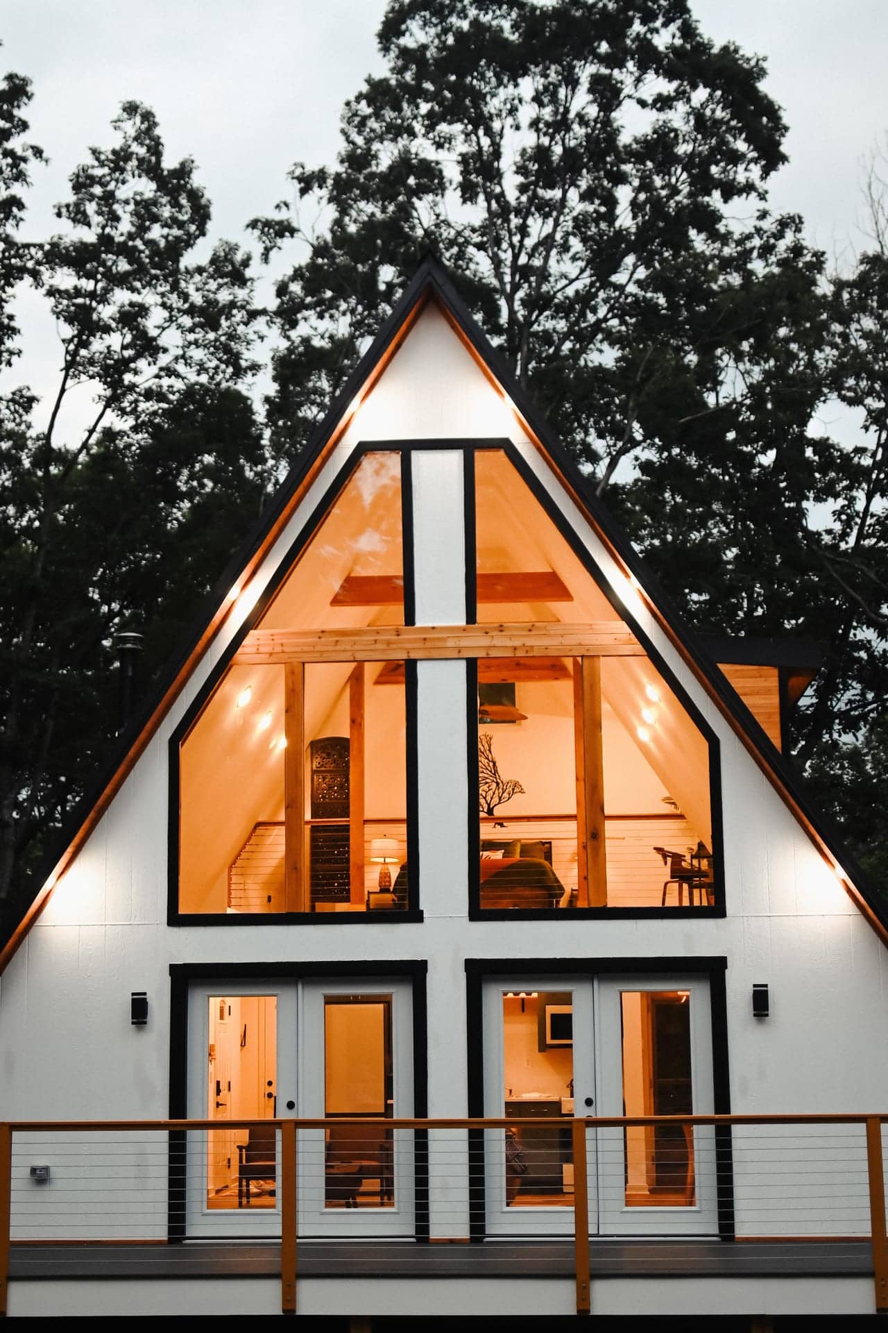 The Sparrow's glass front glowing at dusk under the A-frame roof