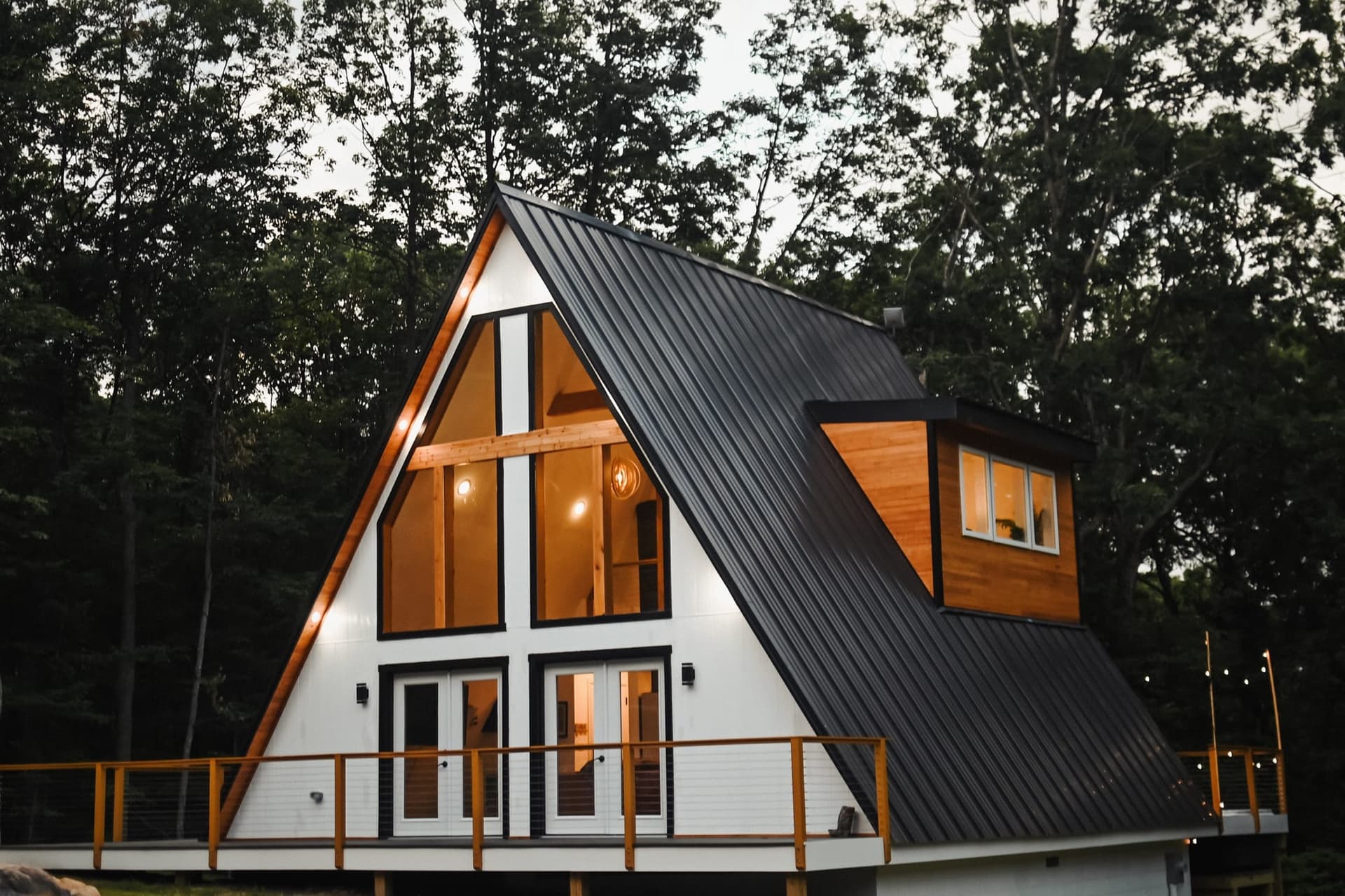 The Sparrow A-frame cabin lit up at dusk among the trees outside Luray, Virginia