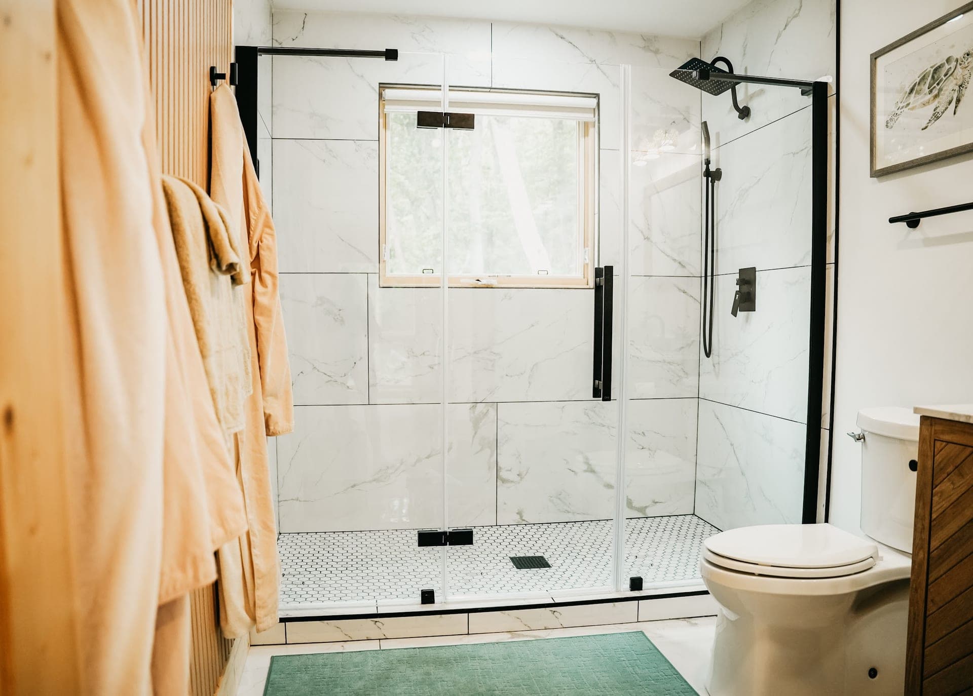 The bathroom, with its tiled walk-in shower and glass door